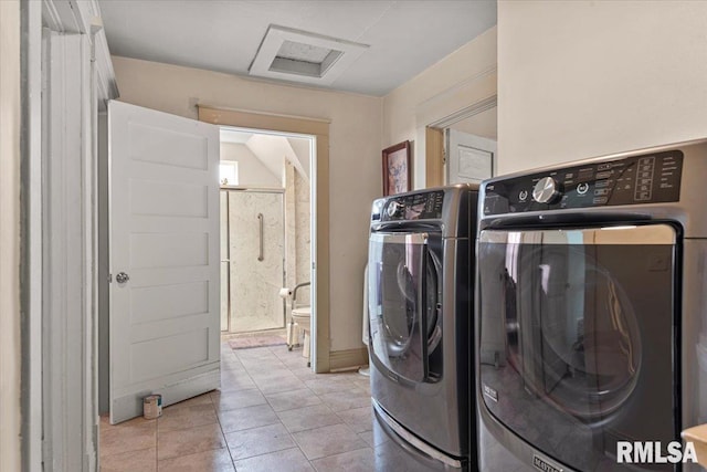 laundry area featuring attic access, washer and clothes dryer, light tile patterned flooring, and laundry area