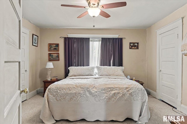 bedroom featuring light carpet, baseboards, and ceiling fan