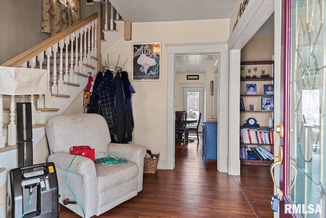 sitting room with dark wood-type flooring and stairs