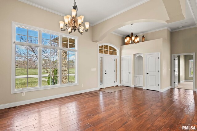 entrance foyer with visible vents, baseboards, a chandelier, and wood finished floors