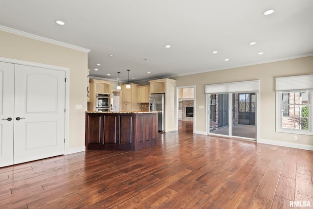 kitchen with crown molding, a peninsula, appliances with stainless steel finishes, dark wood-type flooring, and open floor plan