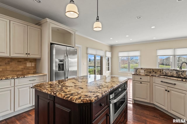 kitchen with ornamental molding, a sink, stainless steel appliances, and dark wood-type flooring