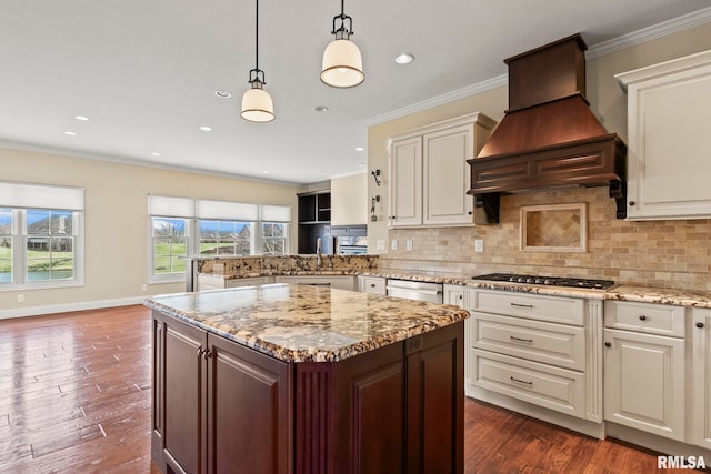kitchen featuring ornamental molding, a sink, premium range hood, and appliances with stainless steel finishes