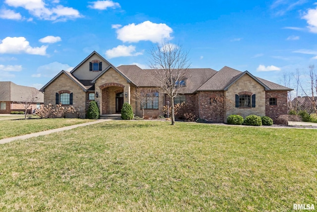 french country style house featuring stone siding, brick siding, a shingled roof, and a front lawn