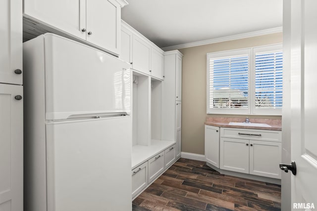 mudroom featuring wood finish floors, a sink, ornamental molding, and baseboards