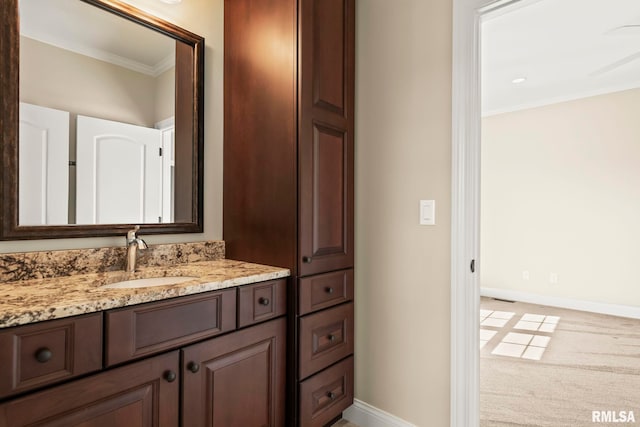 bathroom with baseboards, ornamental molding, and vanity