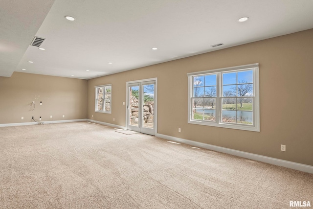 unfurnished room with recessed lighting, baseboards, light colored carpet, and visible vents