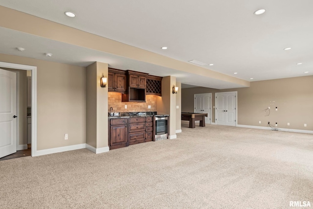 living room featuring light colored carpet, recessed lighting, baseboards, and bar