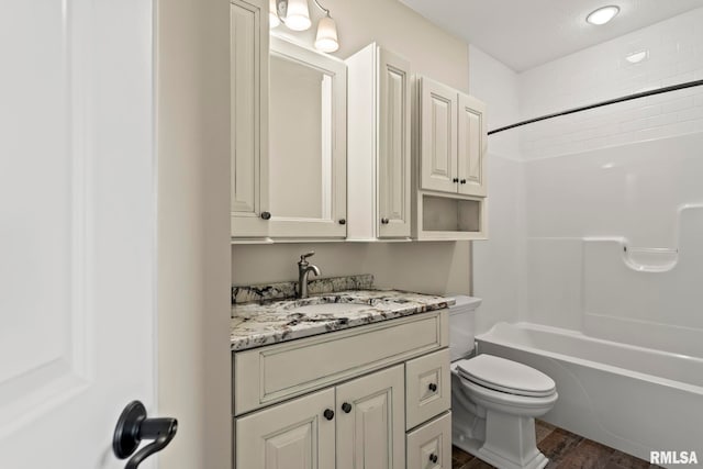 bathroom featuring toilet, vanity, bathing tub / shower combination, and wood finished floors
