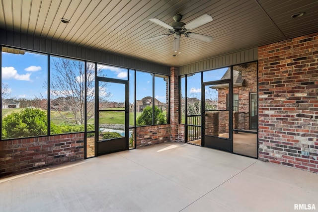 unfurnished sunroom with ceiling fan
