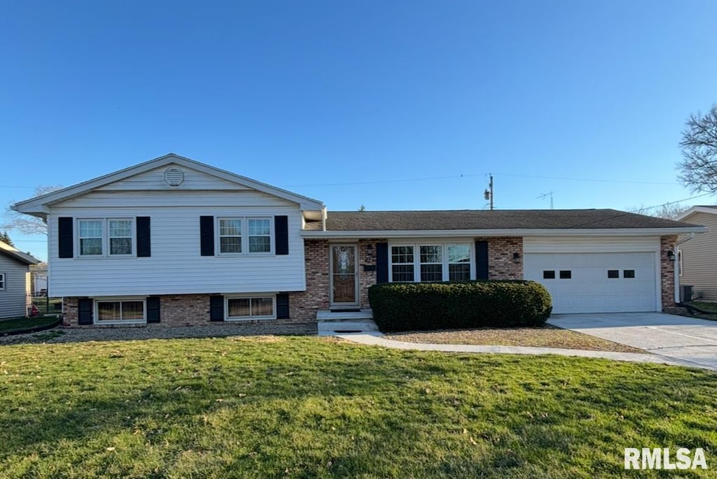 417 Pendik St, Jacksonville, IL 62650 - tri-level home featuring an attached garage, driveway, a front lawn, and brick siding