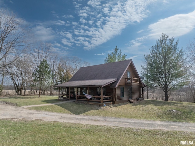 view of front of property with a shingled roof, driveway, a front yard, and log exterior