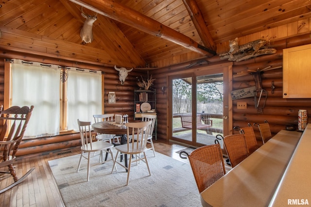 dining room with vaulted ceiling with beams, light wood-type flooring, and wooden ceiling