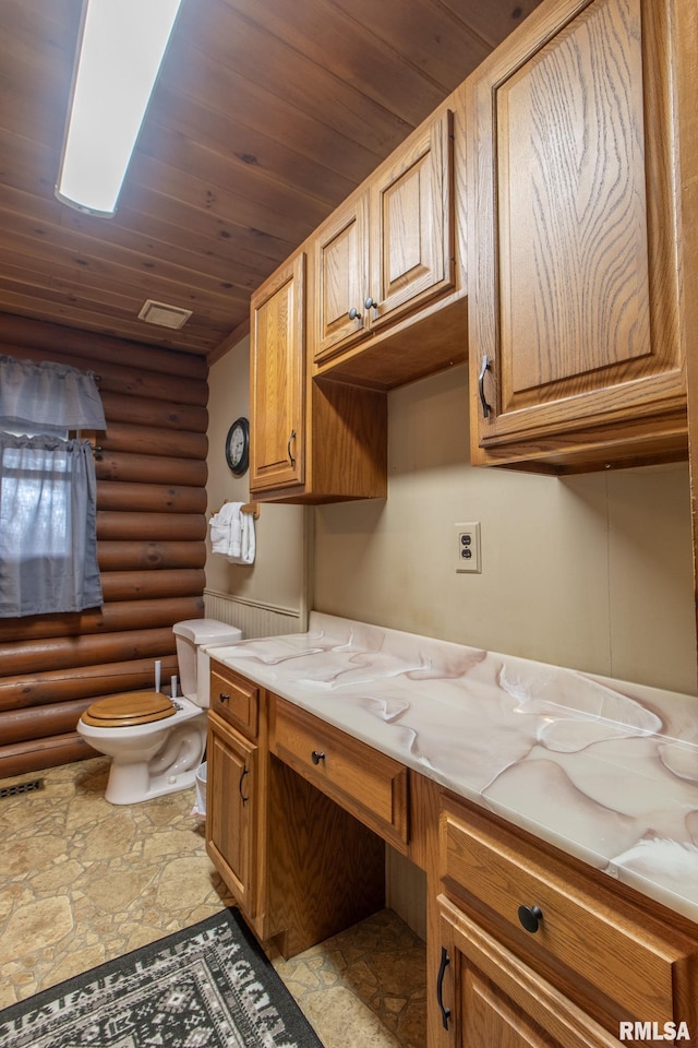 bathroom featuring vanity, toilet, log walls, wood ceiling, and stone tile flooring