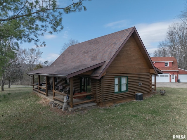 rear view of house featuring central AC, a garage, a yard, and log exterior