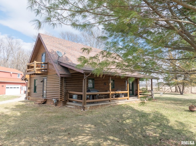 view of front of home featuring log exterior, a garage, a front lawn, roof with shingles, and a porch
