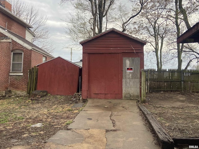 view of outdoor structure featuring an outbuilding and fence