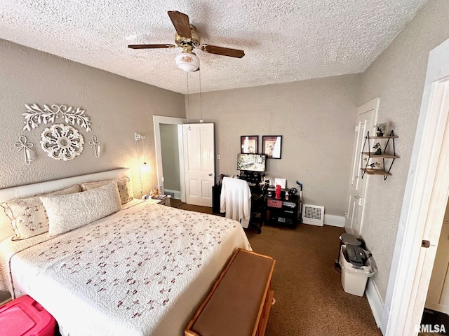 bedroom with a textured wall, baseboards, a textured ceiling, dark carpet, and ceiling fan
