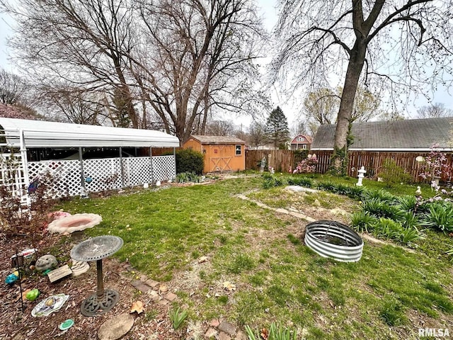 view of yard with an outdoor fire pit, a fenced backyard, an outdoor structure, and a shed