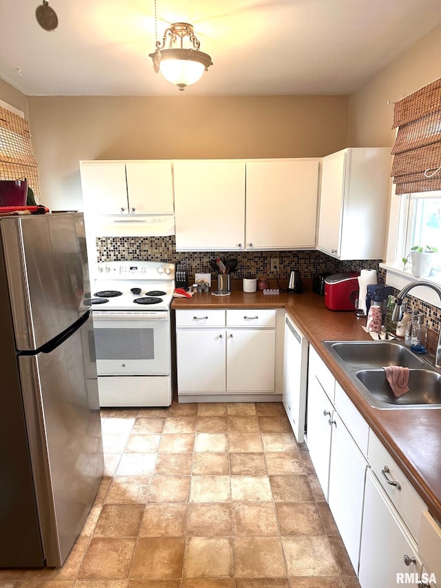 kitchen featuring white cabinets, white appliances, tasteful backsplash, under cabinet range hood, and a sink