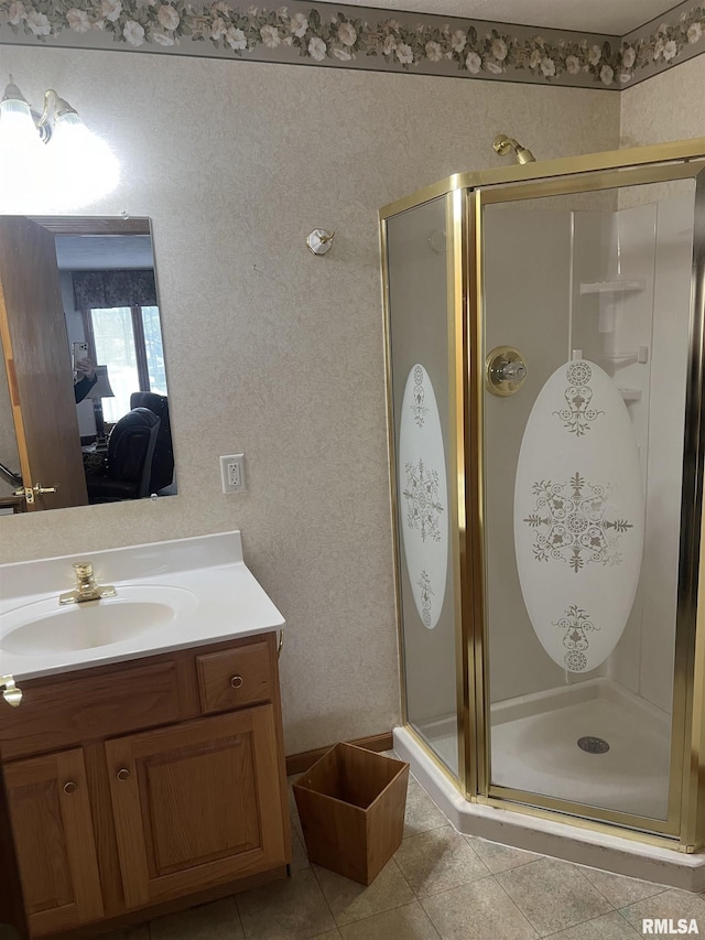 ensuite bathroom featuring tile patterned floors, vanity, ensuite bathroom, and a shower stall