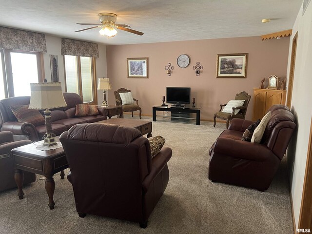 carpeted living area with a ceiling fan