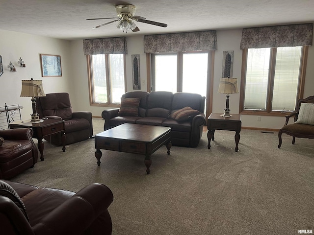 living area with a textured ceiling, baseboards, visible vents, ceiling fan, and carpet