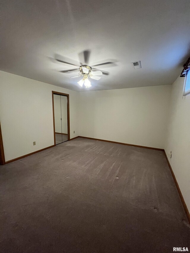 carpeted empty room with baseboards, ceiling fan, and visible vents
