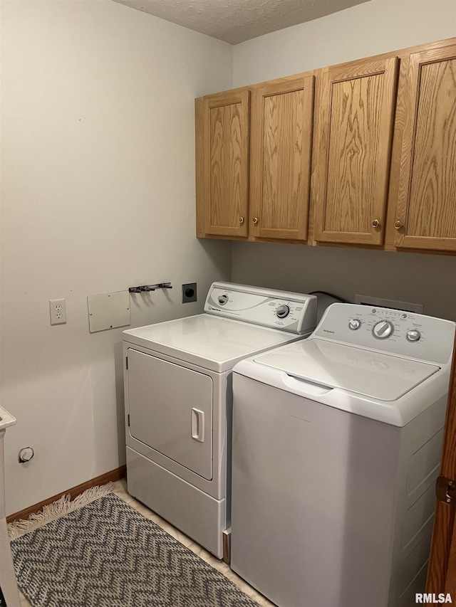 laundry room featuring cabinet space, baseboards, separate washer and dryer, and a textured ceiling