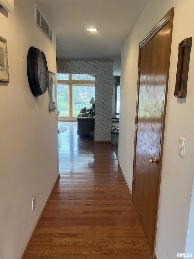corridor with baseboards, visible vents, recessed lighting, and wood finished floors