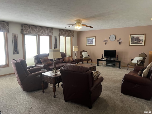 living room with baseboards, a ceiling fan, carpet floors, and a textured ceiling