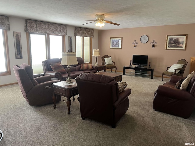 living room featuring baseboards, carpet floors, a textured ceiling, and a ceiling fan