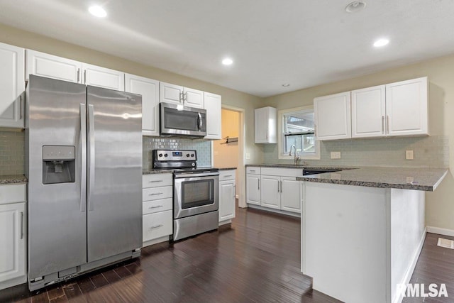kitchen with a sink, decorative backsplash, white cabinets, and stainless steel appliances