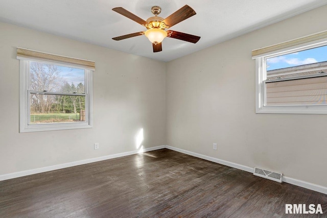empty room with ceiling fan, visible vents, baseboards, and wood finished floors