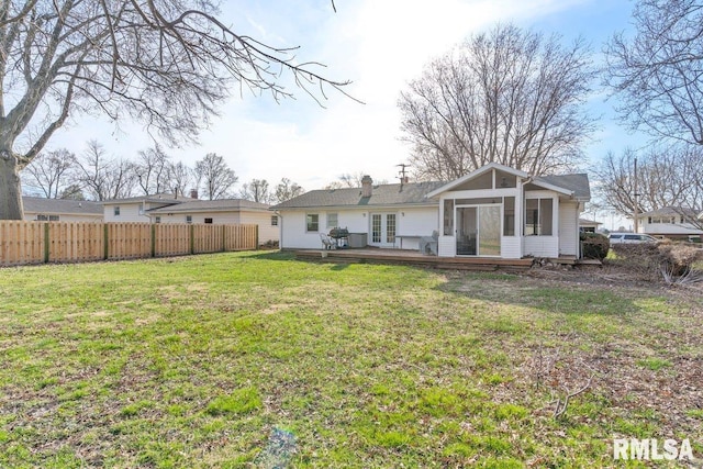 rear view of property with a deck, french doors, fence private yard, and a yard