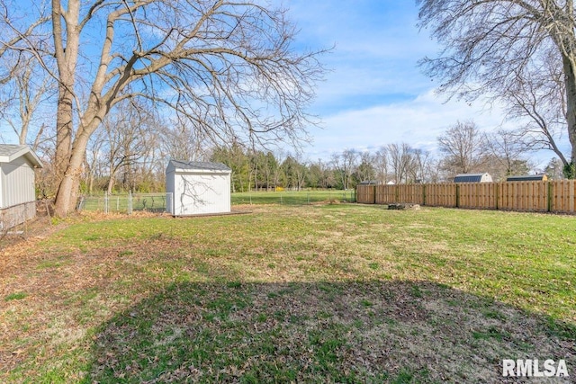 view of yard featuring fence, an outbuilding, and a storage unit