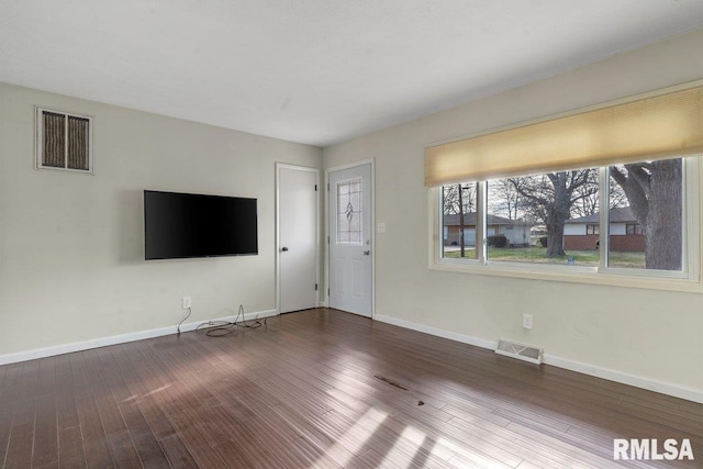 unfurnished living room featuring visible vents, baseboards, and wood finished floors