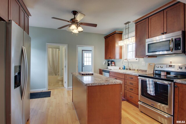 214 N Ohio St, Camp Point, IL 62320 - kitchen featuring a center island, a sink, light wood-type flooring, and appliances with stainless steel finishes