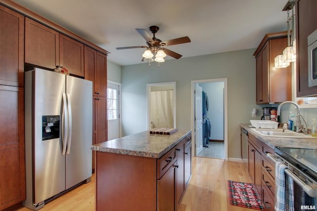 214 N Ohio St, Camp Point, IL 62320 - kitchen featuring light wood-type flooring, a kitchen island, a sink, ceiling fan, and appliances with stainless steel finishes