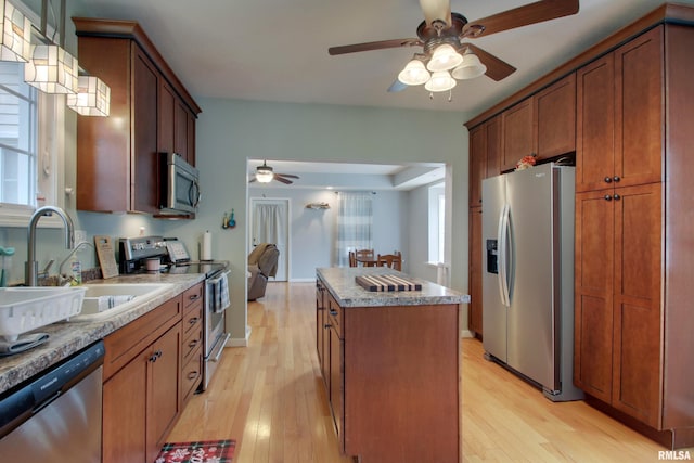 214 N Ohio St, Camp Point, IL 62320 - kitchen featuring light wood finished floors, a kitchen island, a ceiling fan, and stainless steel appliances