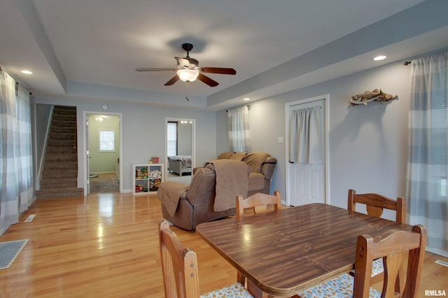 214 N Ohio St, Camp Point, IL 62320 - dining room with a tray ceiling, stairs, light wood finished floors, ceiling fan, and visible vents