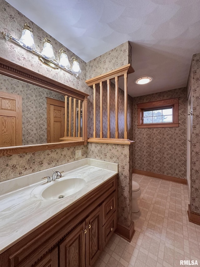 290 W Railroad St, Roseville, IL 61473 - full bathroom with tile patterned floors, toilet, vanity, baseboards, and wallpapered walls