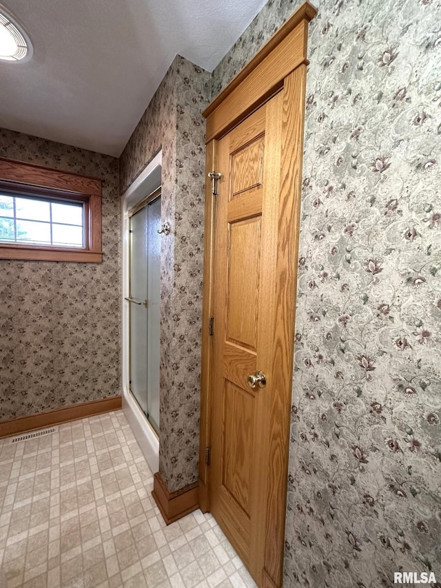 290 W Railroad St, Roseville, IL 61473 - full bath with wallpapered walls, a shower with shower door, tile patterned floors, and baseboards