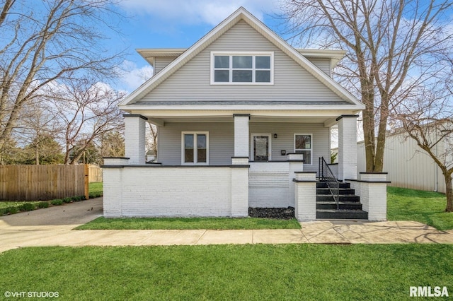 418 4th St, Illiopolis, IL 62539 - view of front of house with covered porch, brick siding, a front yard, and fence