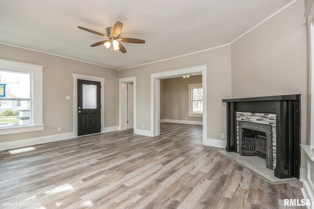 418 4th St, Illiopolis, IL 62539 - unfurnished living room with crown molding, a tile fireplace, wood finished floors, baseboards, and ceiling fan