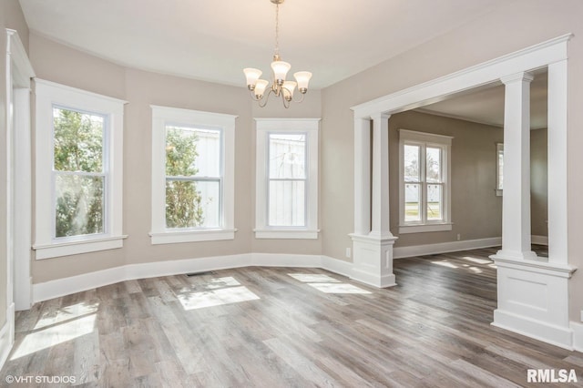 418 4th St, Illiopolis, IL 62539 - unfurnished dining area with baseboards, wood finished floors, and decorative columns