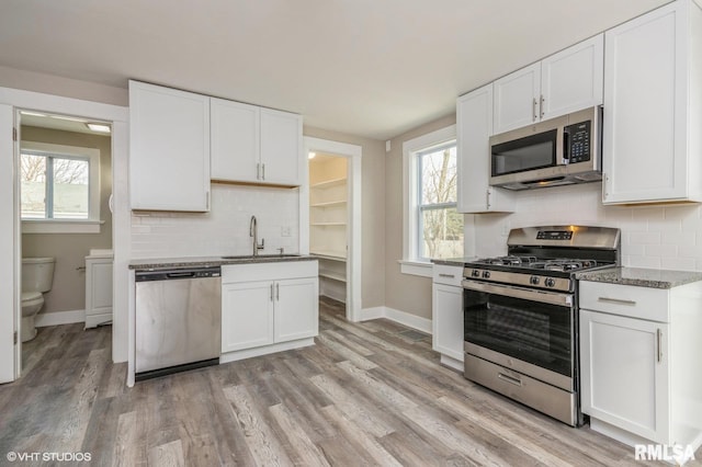 418 4th St, Illiopolis, IL 62539 - kitchen with white cabinets, a sink, plenty of natural light, and appliances with stainless steel finishes