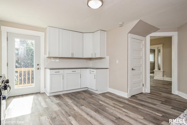 418 4th St, Illiopolis, IL 62539 - kitchen featuring white cabinetry, tasteful backsplash, baseboards, and light wood-type flooring