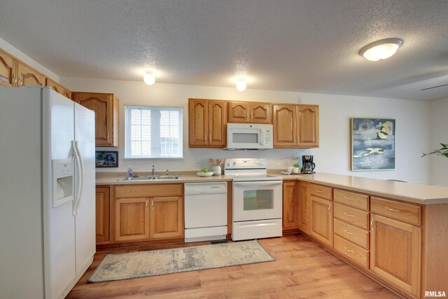 4804 Elm St, Quincy, IL 62305 - kitchen with white appliances, a textured ceiling, a peninsula, light wood-type flooring, and a sink