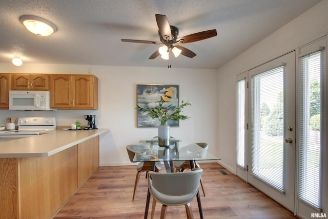4804 Elm St, Quincy, IL 62305 - kitchen featuring white appliances, a peninsula, ceiling fan, light wood finished floors, and light countertops